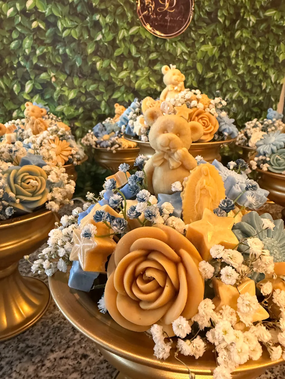 Blue and peach everlasting roses displayed on a golden pedestal