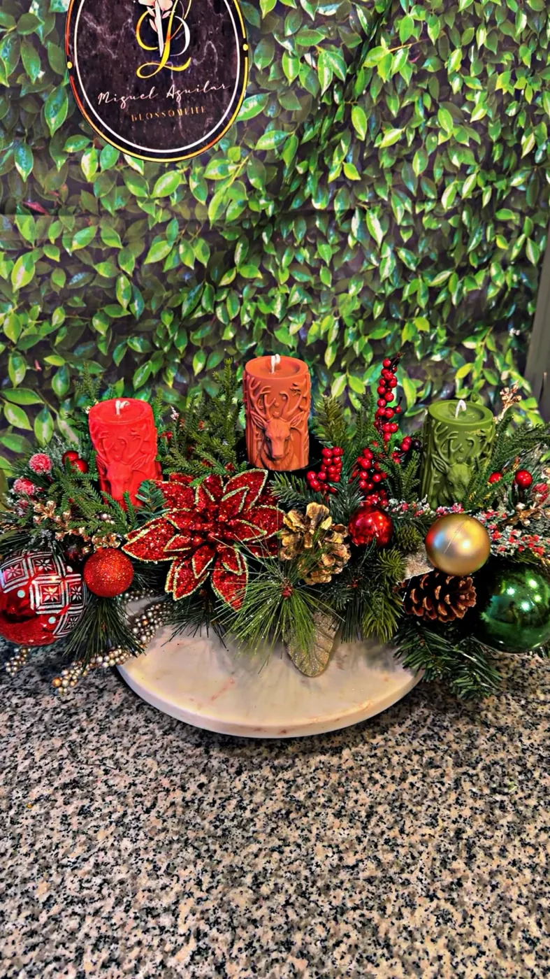 Holiday centerpiece with red candles and evergreen greenery