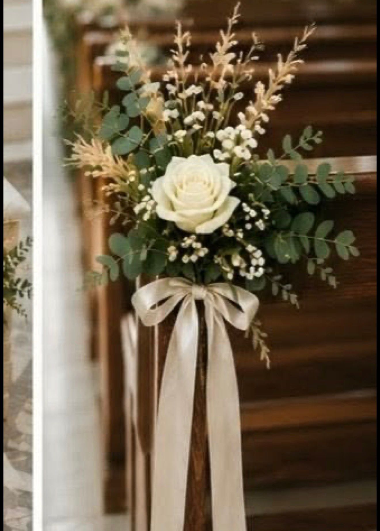White ceremony floral arrangement with greenery and ribbon