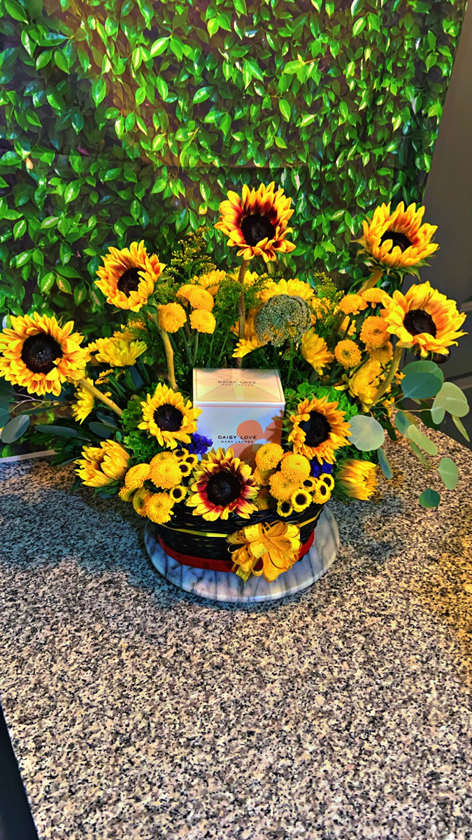 Sunflower arrangement in a decorative blue container
